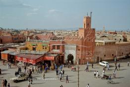 Image du Maroc Professionnelle de  Le fidèles accèdent à la Mosquée Kharbouche pour la prière d'Al Asr, cette mosquée située au bout de la fameuse place Jemaa El Fana à sa gauche l'entrée du souk Semmarine et à droite le Derb Dabachi un important passage de la médina de Marrakech, la ville touristique du Maroc. La 4L (voiture Renault 4) est bloqué par un sabot à cette époque déjà, il était strictement interdit de stationner tout le long du mur de la mosquée d'ailleurs plusieurs panneaux le rappel. Jeudi 19 Mai 1988. (Photo / Abdeljalil Bounhar) 